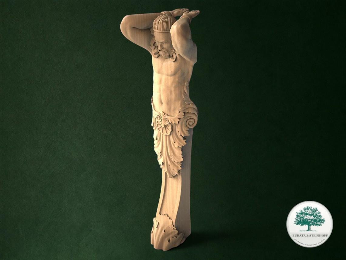 A wooden statue of a man with his arms raised, standing against a dark green background.