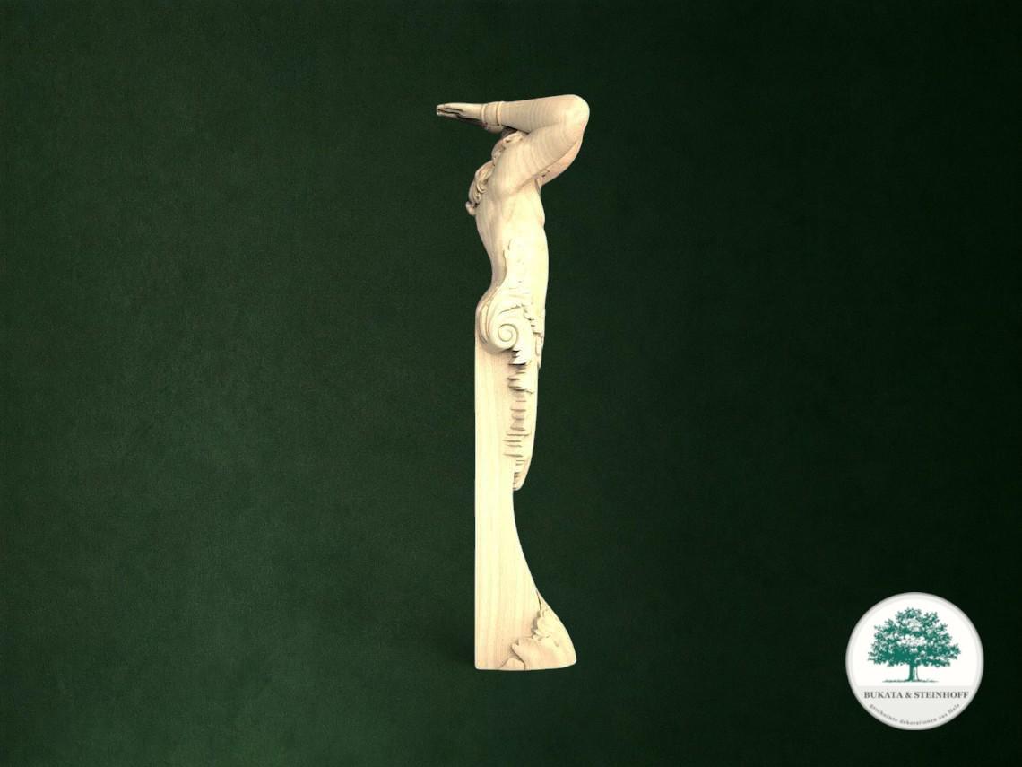 A white wooden sculpture of a human figure with an extended arm is displayed against a dark green background.