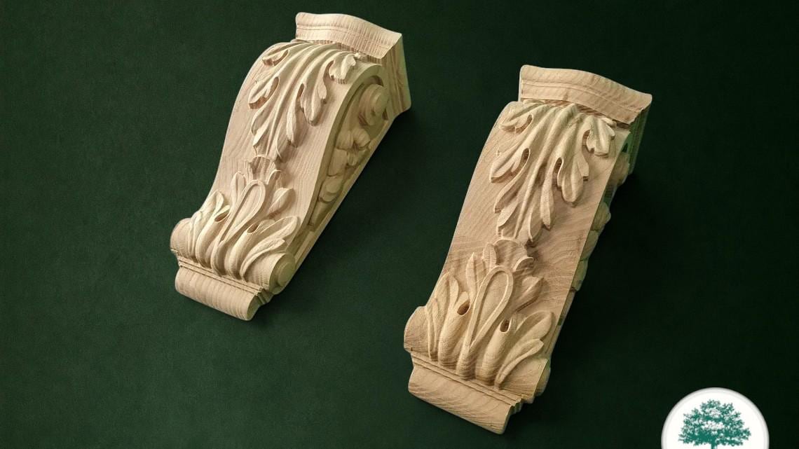 two intricately carved wooden pieces, likely made of wood, displayed against a dark green background.
