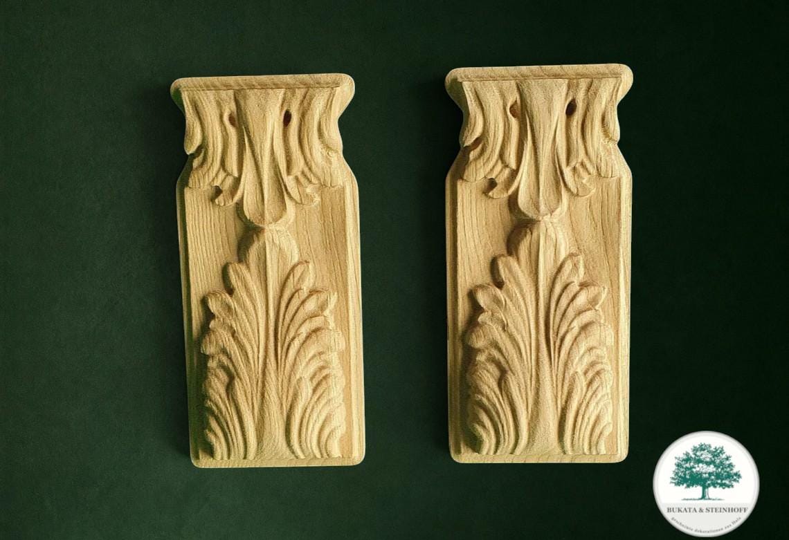 two intricately carved wooden pieces, each with a unique design, set against a dark green background.
