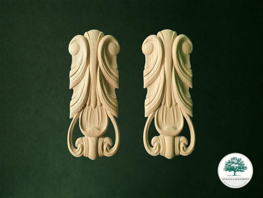 two ornate carved wooden ornaments with intricate designs, displayed against a dark green background.
