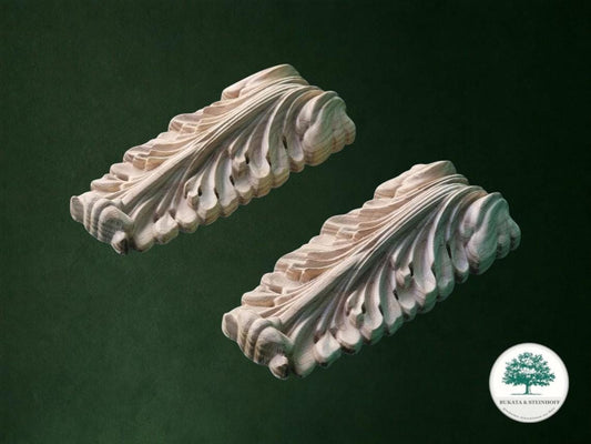 two intricately carved wooden pieces with a detailed, organic design, set against a dark green background.