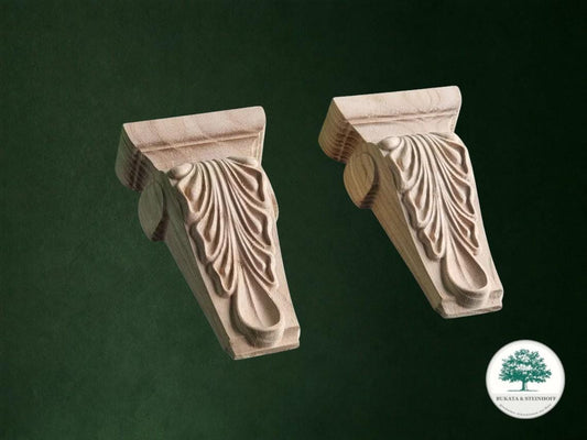 two intricately carved wooden brackets against a dark green background.