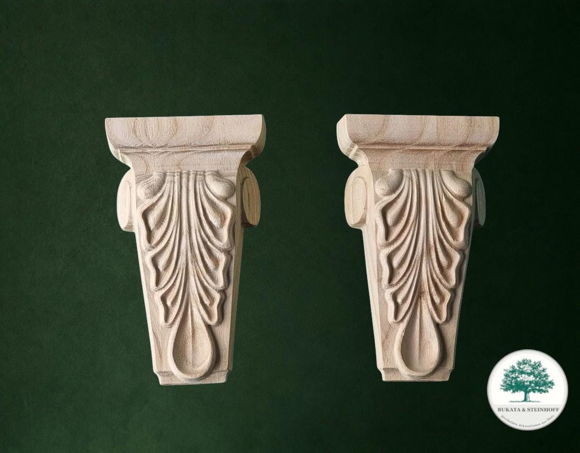 two ornate wooden brackets with intricate carved designs, set against a dark green background.