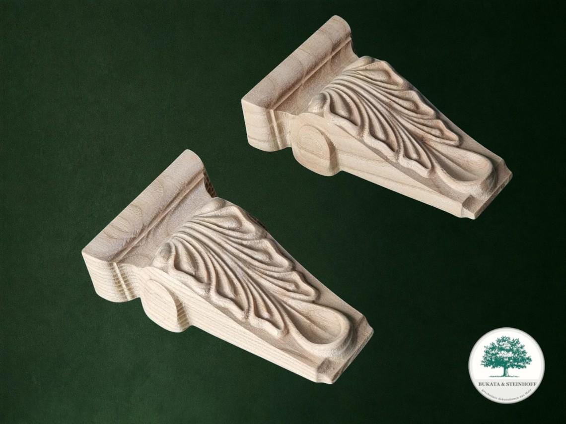 two intricately carved wooden brackets against a dark green background.