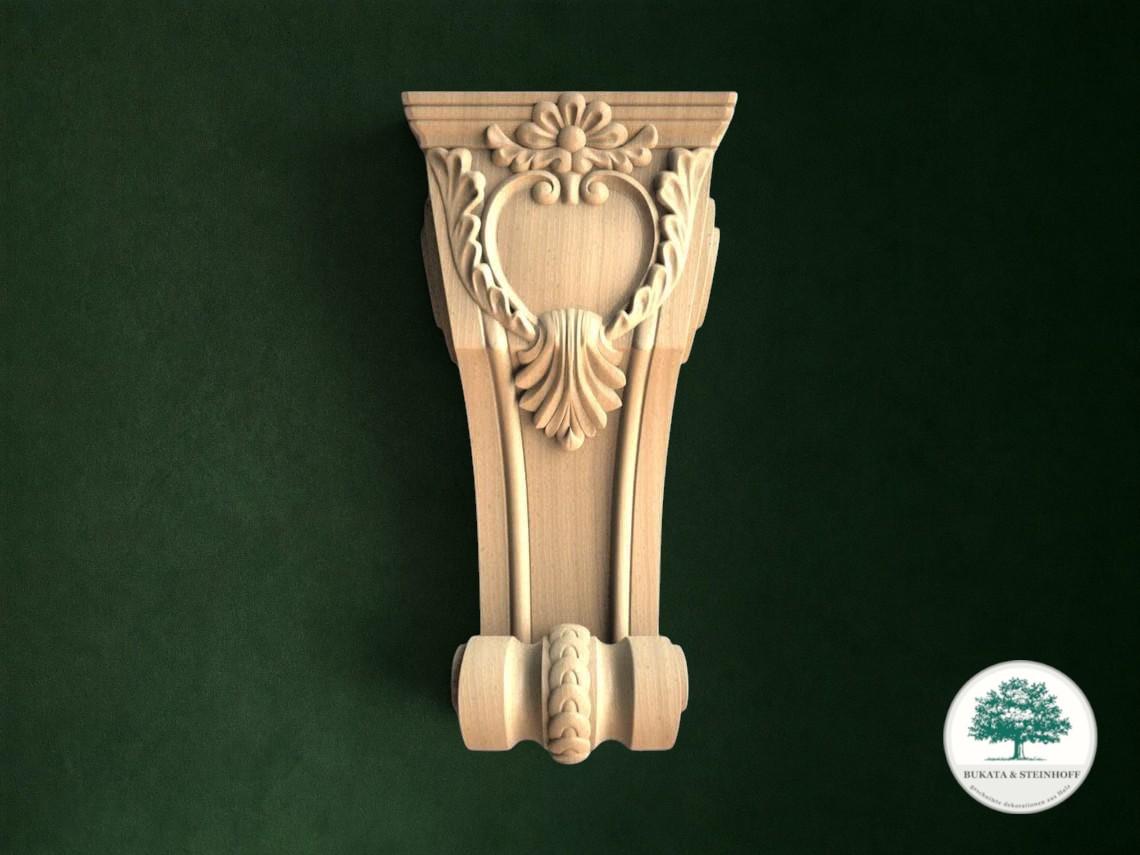 a beautifully carved wooden bracket with an ornate design, set against a dark green background.