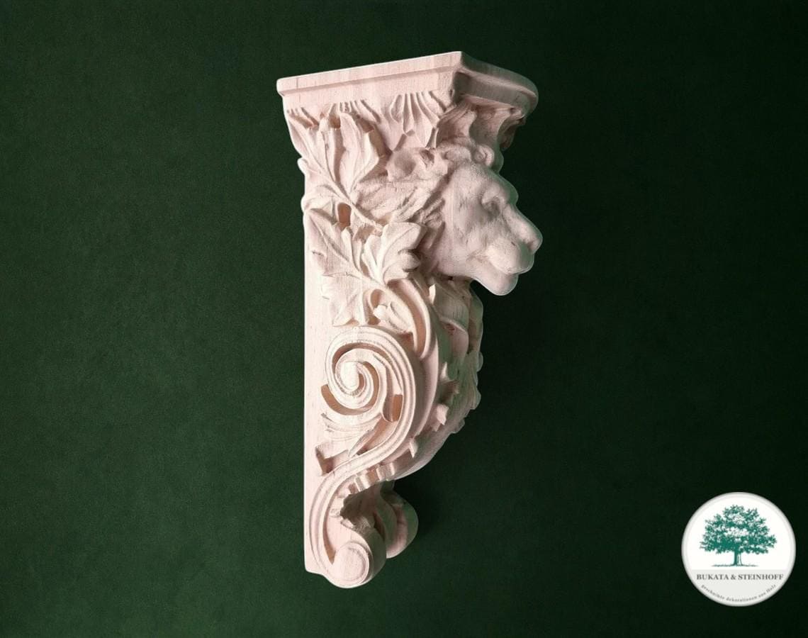A decorative stone carving of a lion's head on a green background.