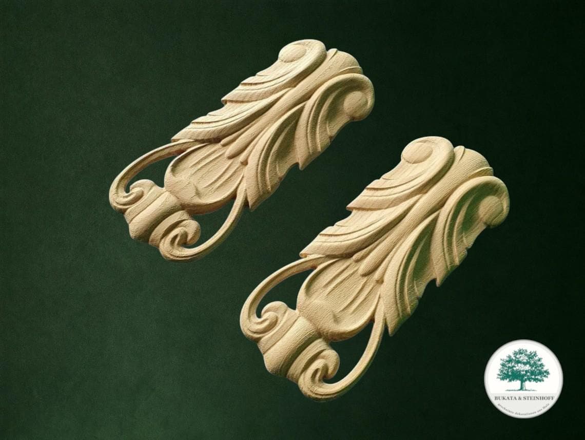 two intricately carved wooden pieces with ornate scrollwork designs, set against a dark green background.