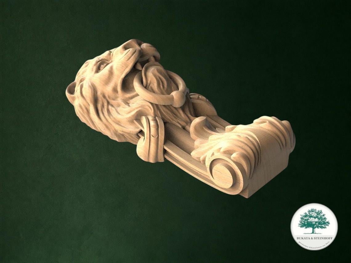 A carved wooden lion head with a decorative scrollwork design, set against a dark green background.
