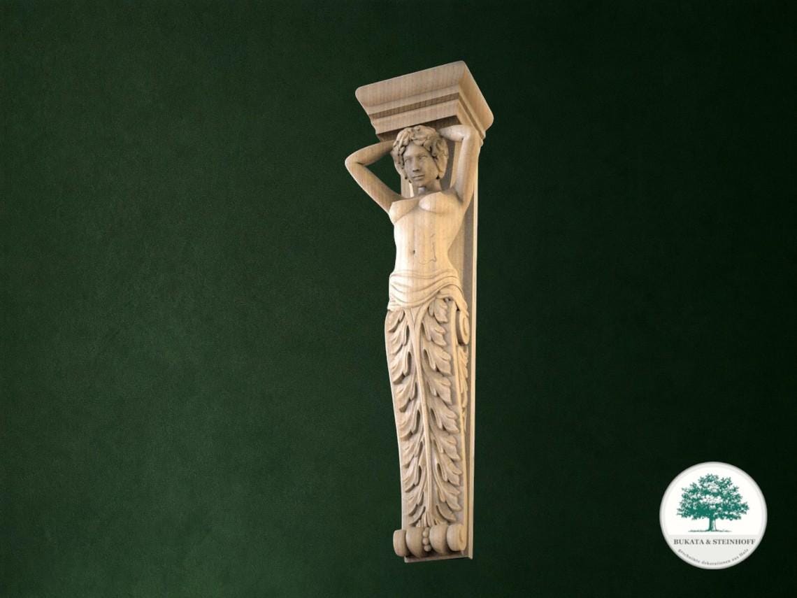 a carved wooden sculpture of a woman with her arms raised, mounted on a wall.
